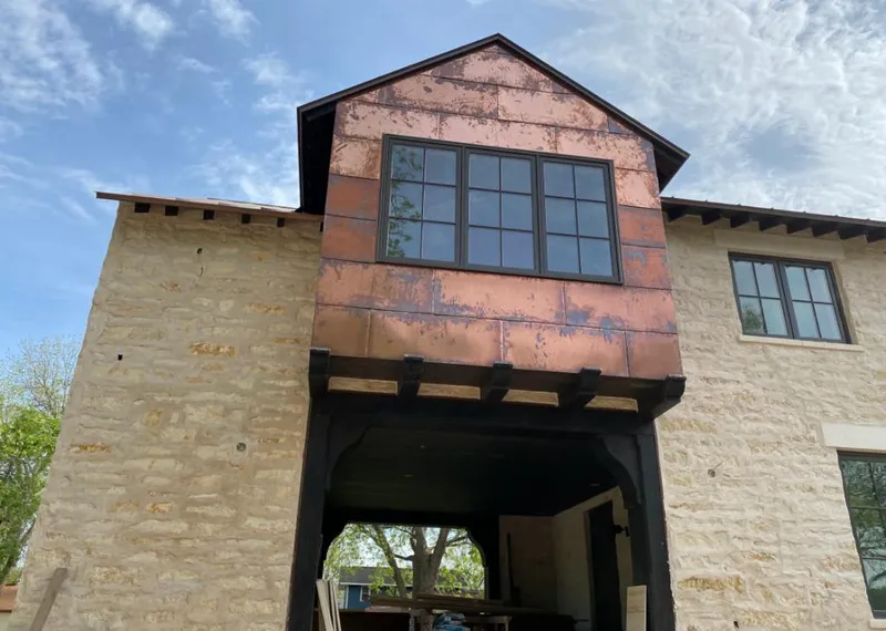 Copper metal panel facade on a stone building for Roof Repair in Swartz Creek