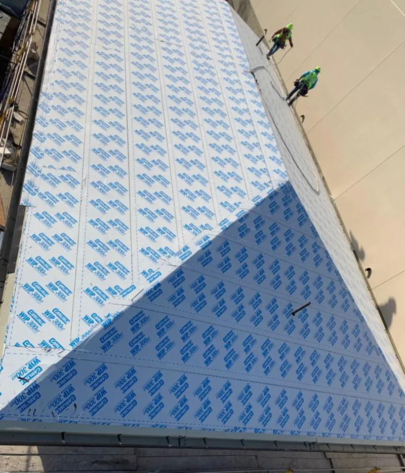 Professional roofers installing underlayment on a metal roof in Swartz Creek